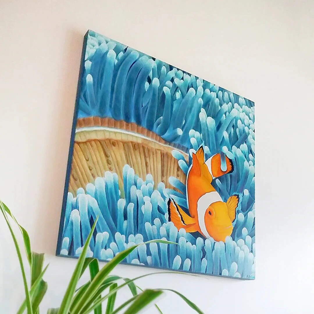 Tableau d'un poisson-clown dans les anémones bleu de taille 40x40 cm accroché sur un mur.
