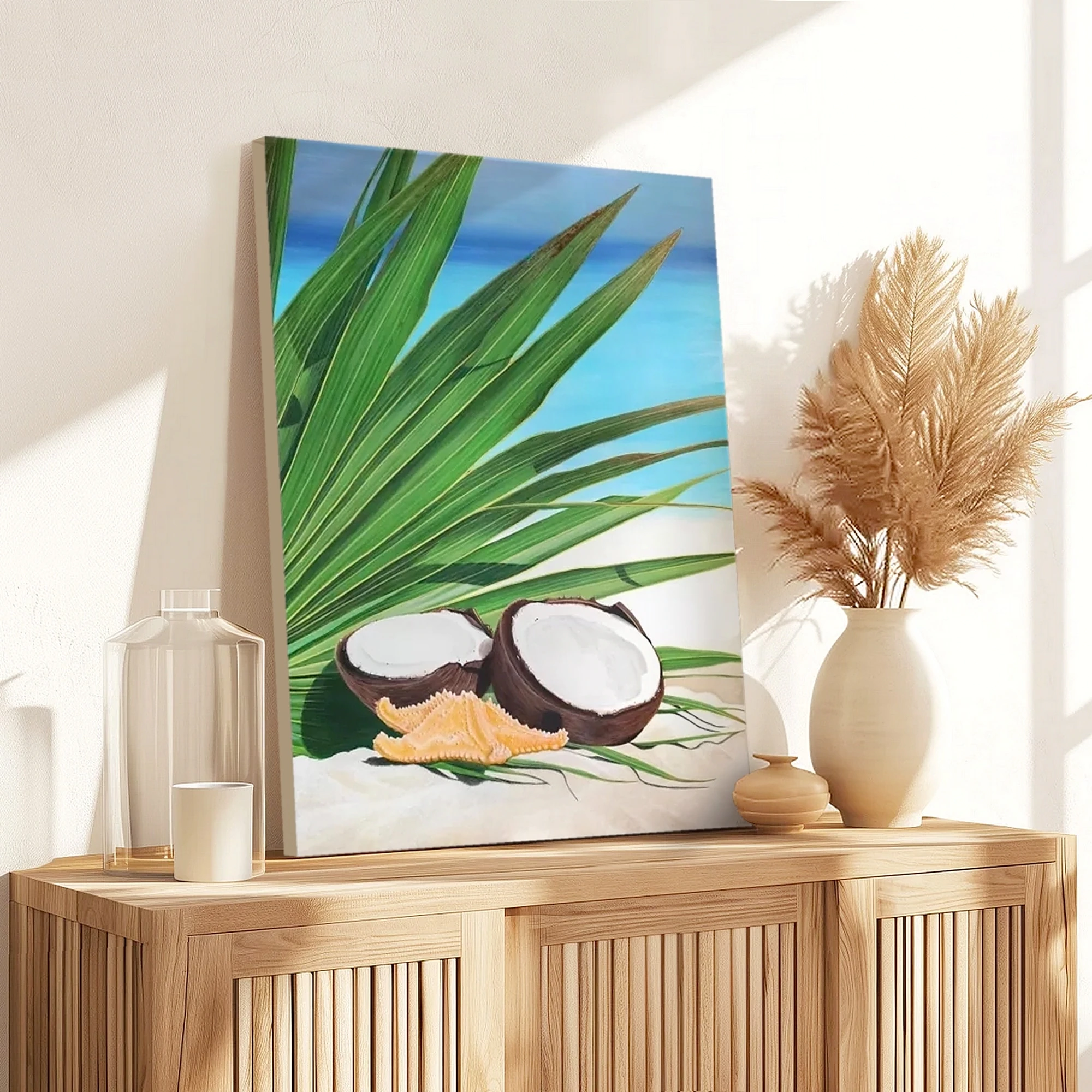 Peinture d'une noix de coco, étoile de mer et feuille de palmiers sur la plage posée sur un meuble pour une décoration bord de mer tropical exotique