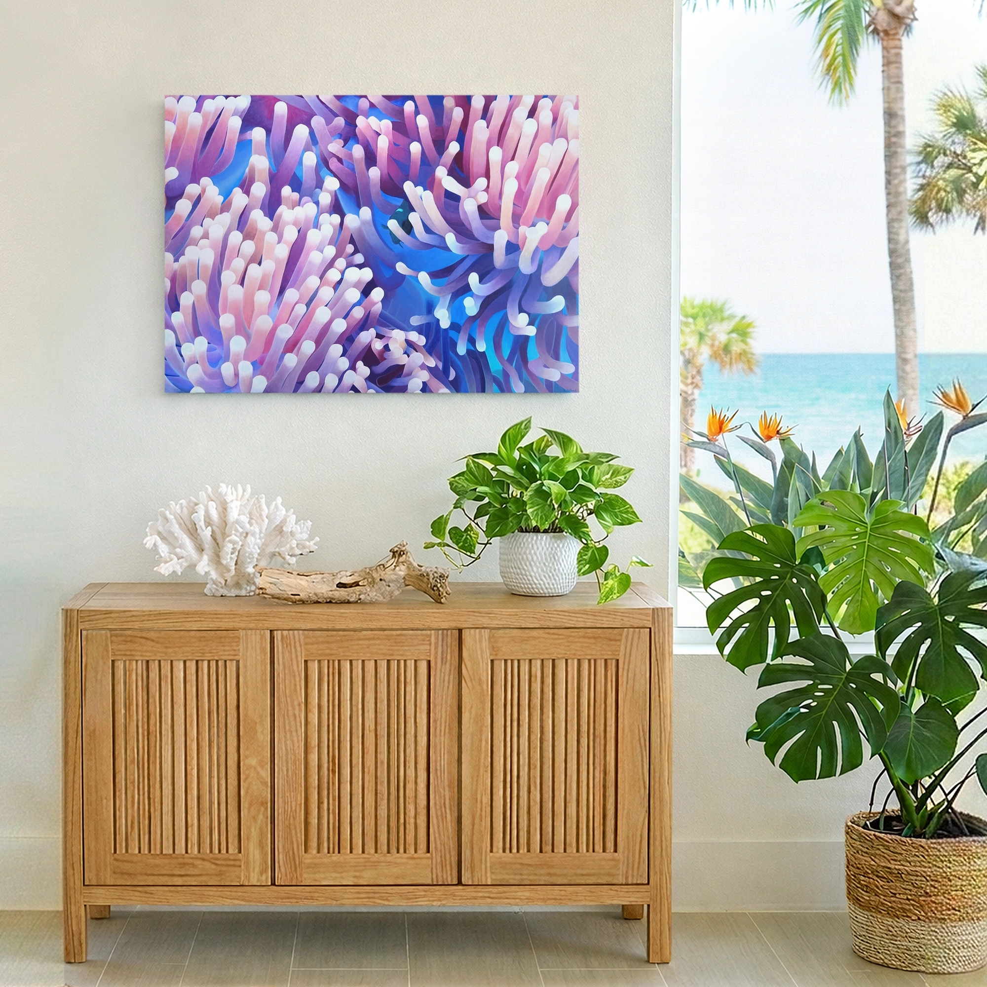 Tableau inspiré du récif corallien avec des anémones de mer colorées accroché au-dessus d’un meuble dans une décoration tropicale.