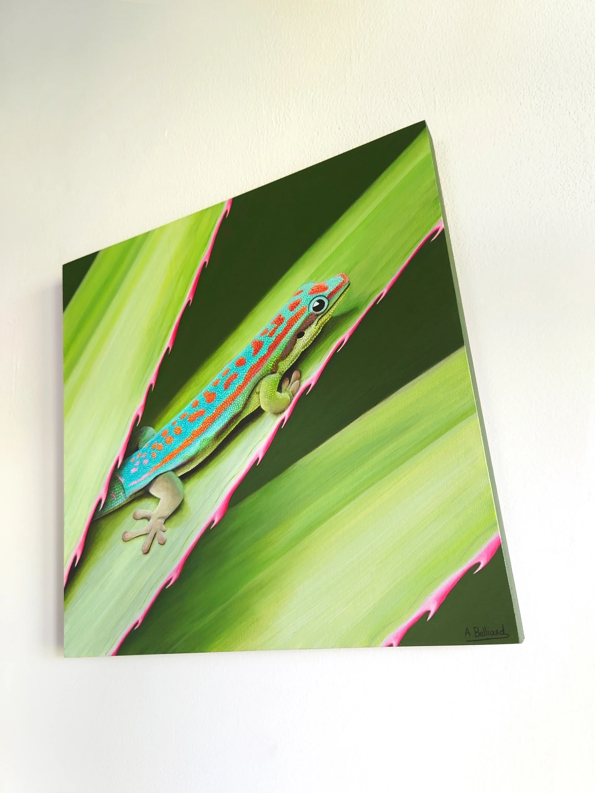 Tableau d'un gecko diurne orné de l'île maurice dans un feuillage tropical de taille 30x30 cm accroché sur un mur.