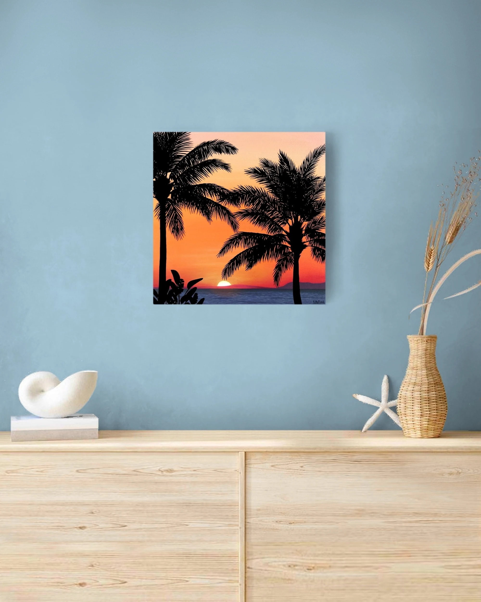 Décoration style tropicale et exotique avec un Petit tableau d'un coucher de soleil orange sur une plage de palmiers.