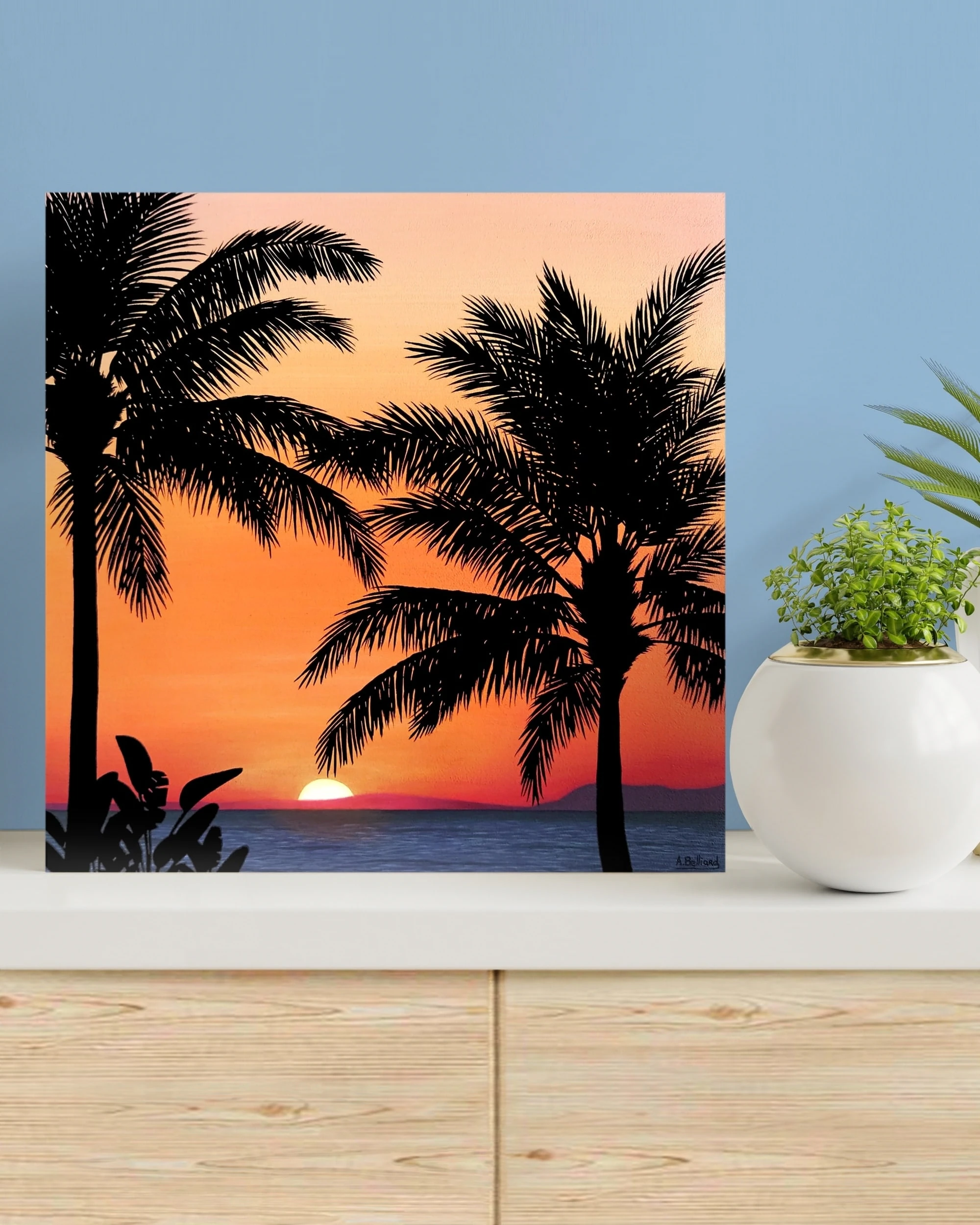 Décoration tropicale et exotique avec un Petit tableau d'un coucher de soleil orange sur une plage de palmiers.
