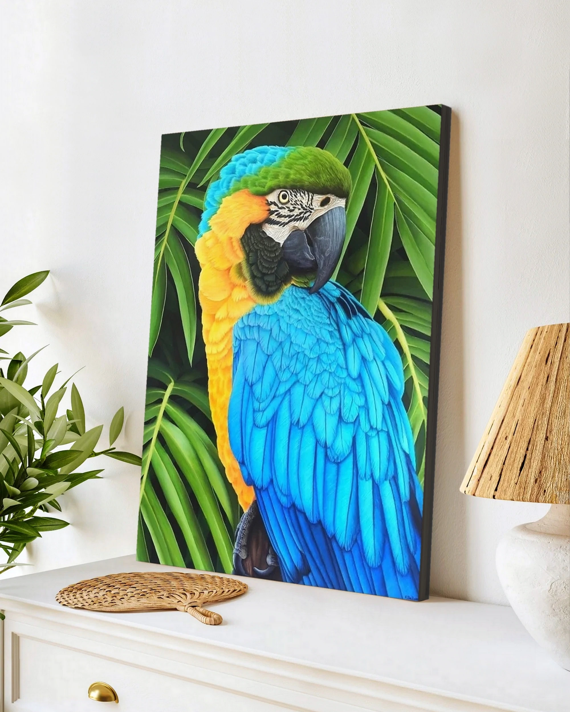 Tableau en peinture d'un perroquet ararauna dans la jungle posée sur un meuble pour une décoration tropical exotique