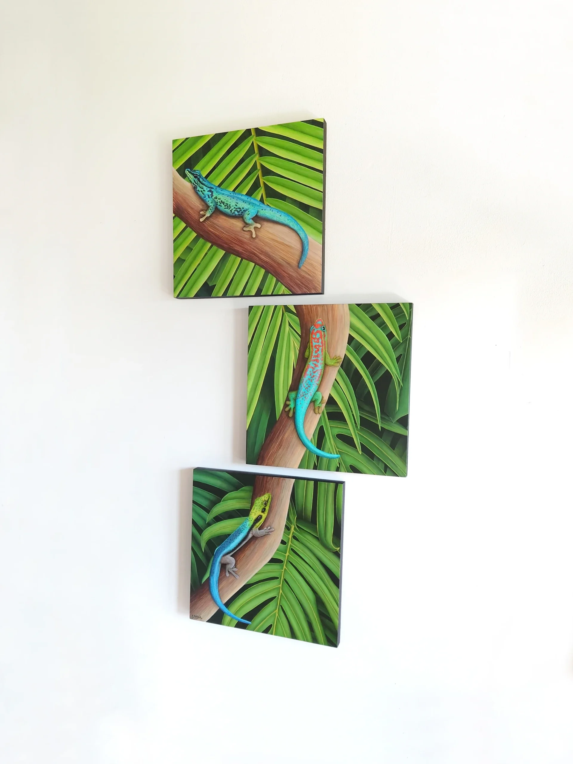 Peinture acrylique de trois lézards geckos dans la jungle de la forêt tropicale de taille 30x90 cm accroché sur un mur.