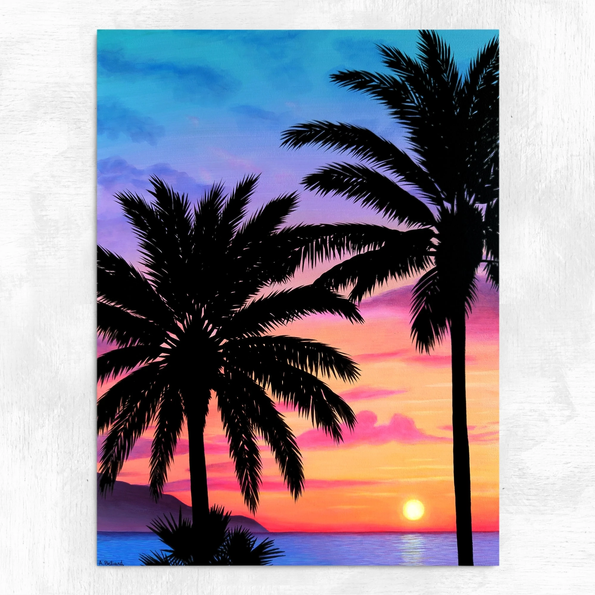 Tableau d'un coucher de soleil sur la mer, avec des palmiers devant réalisé par l'artiste peintre pastelliste Aline Belliard en peinture acrylique sur bois.