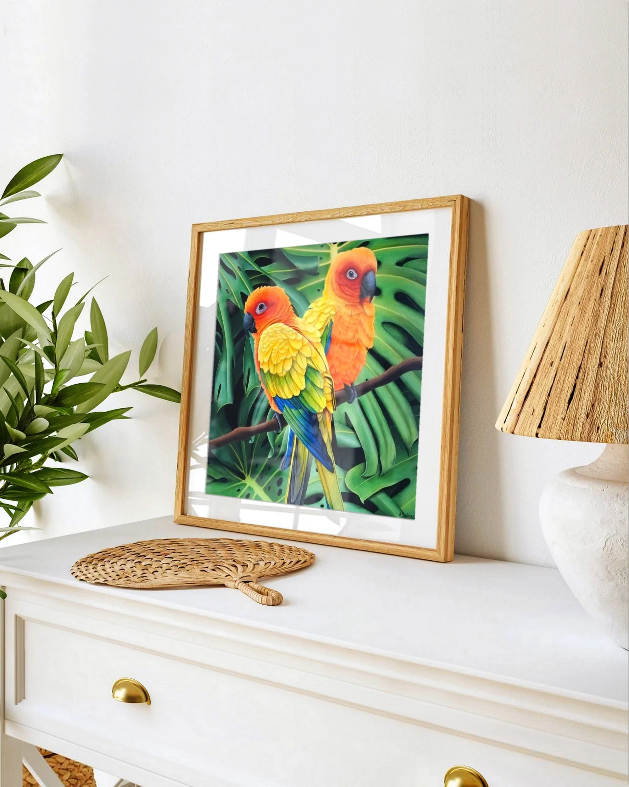 Affiche d'art d'une peinture d'oiseaux conures soleil posée sur un meuble pour une décoration tropicale