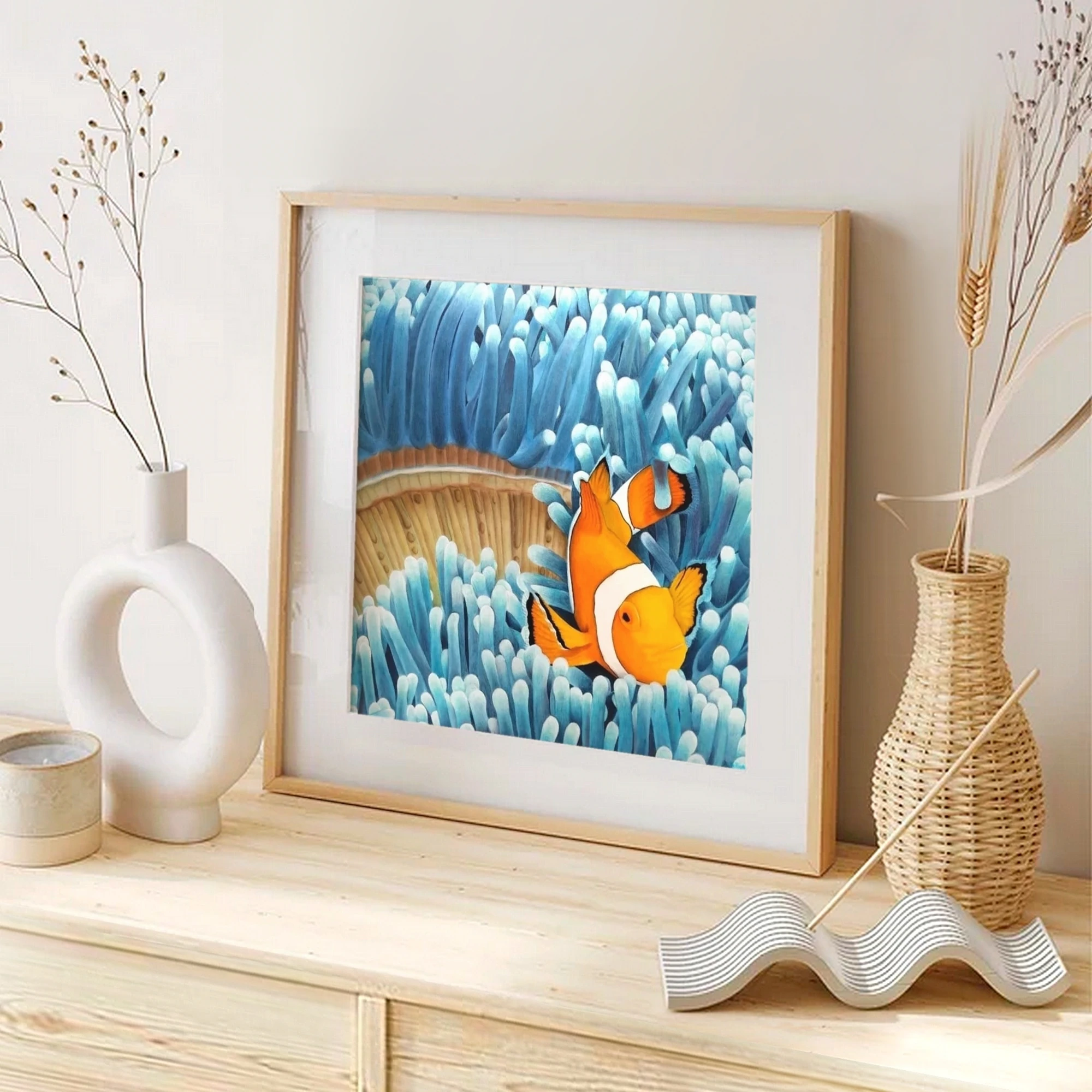 Impression d'art d'une peinture de poisson clown dans les anémones bleues posée sur un meuble pour une décoration bord de mer tropical exotique