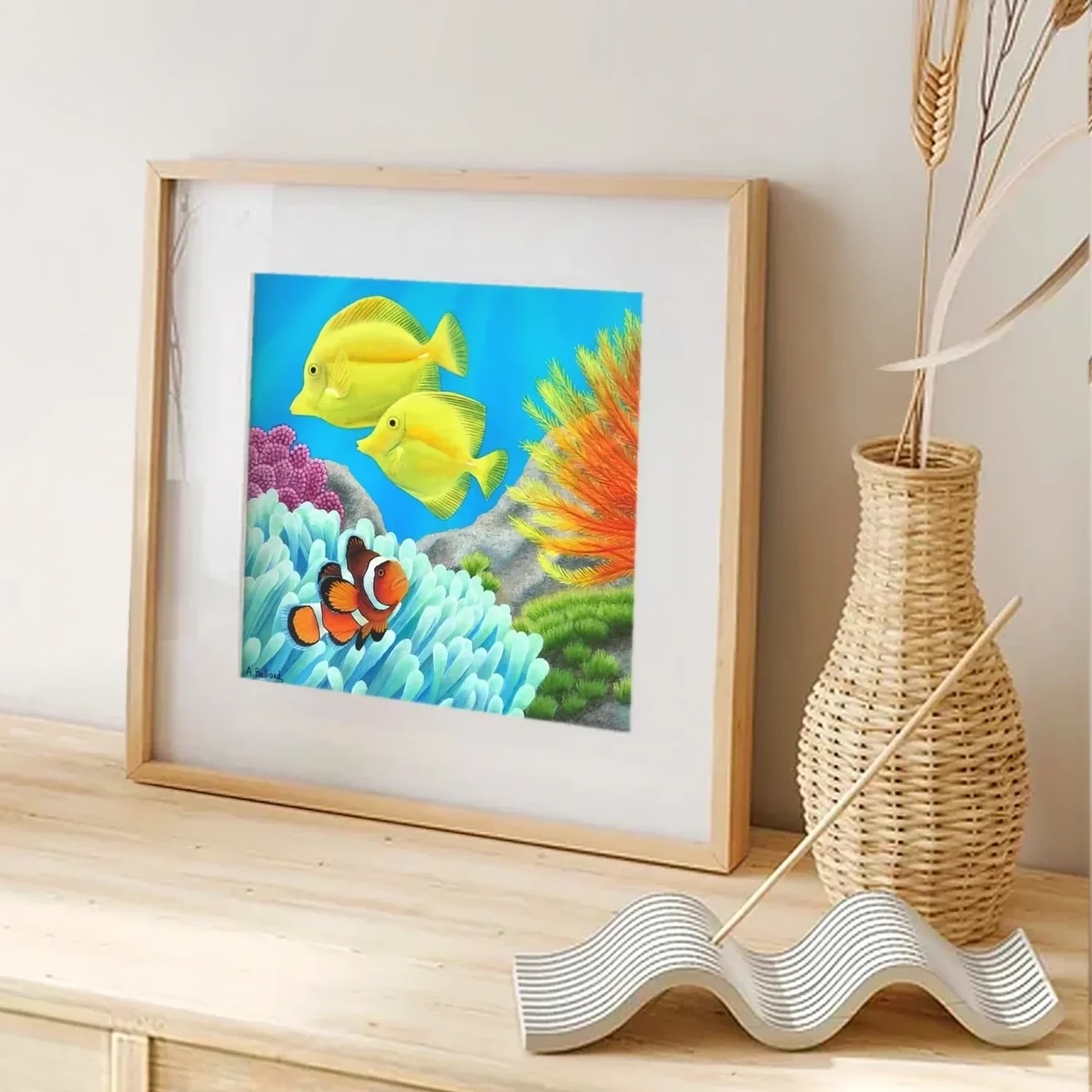 Impression d'art d'une peinture de poissons colorés dans les récifs de l'océan posée sur un meuble pour une décoration bord de mer tropical exotique