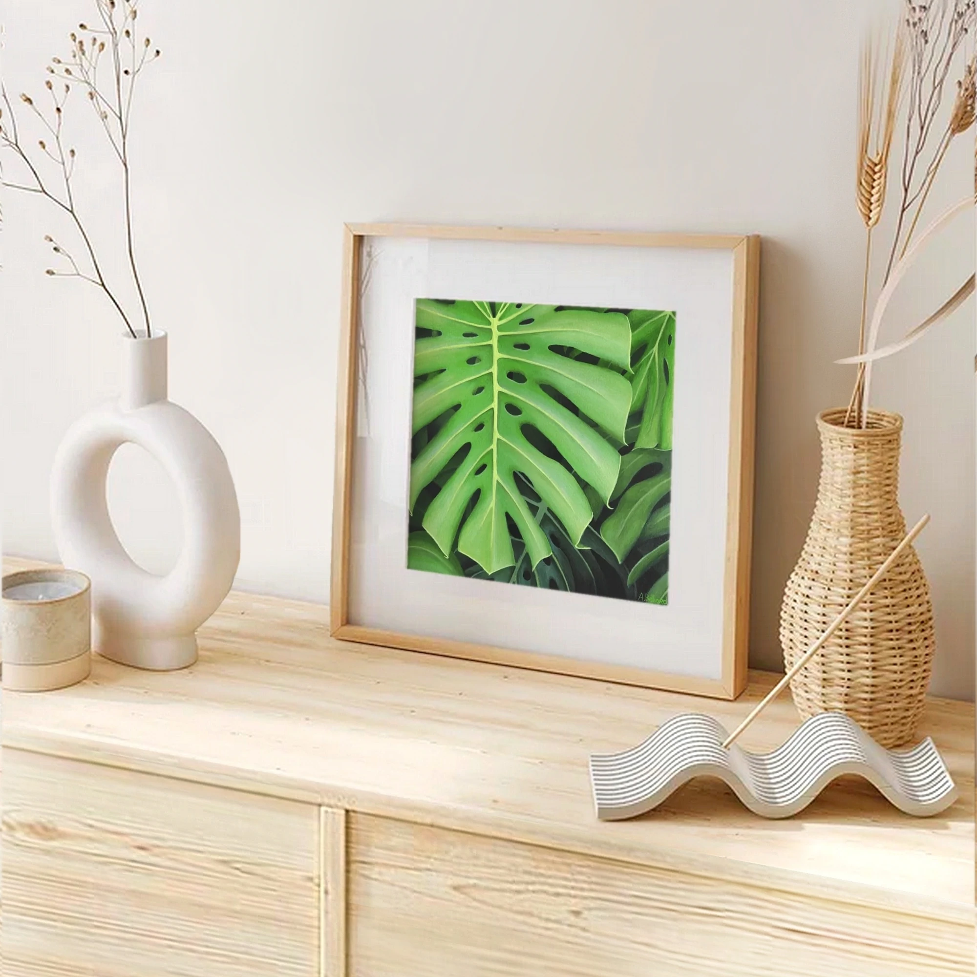 Impression d'art d'une peinture d'un feuillage de plante monstera posée sur un meuble pour une décoration tropical exotique