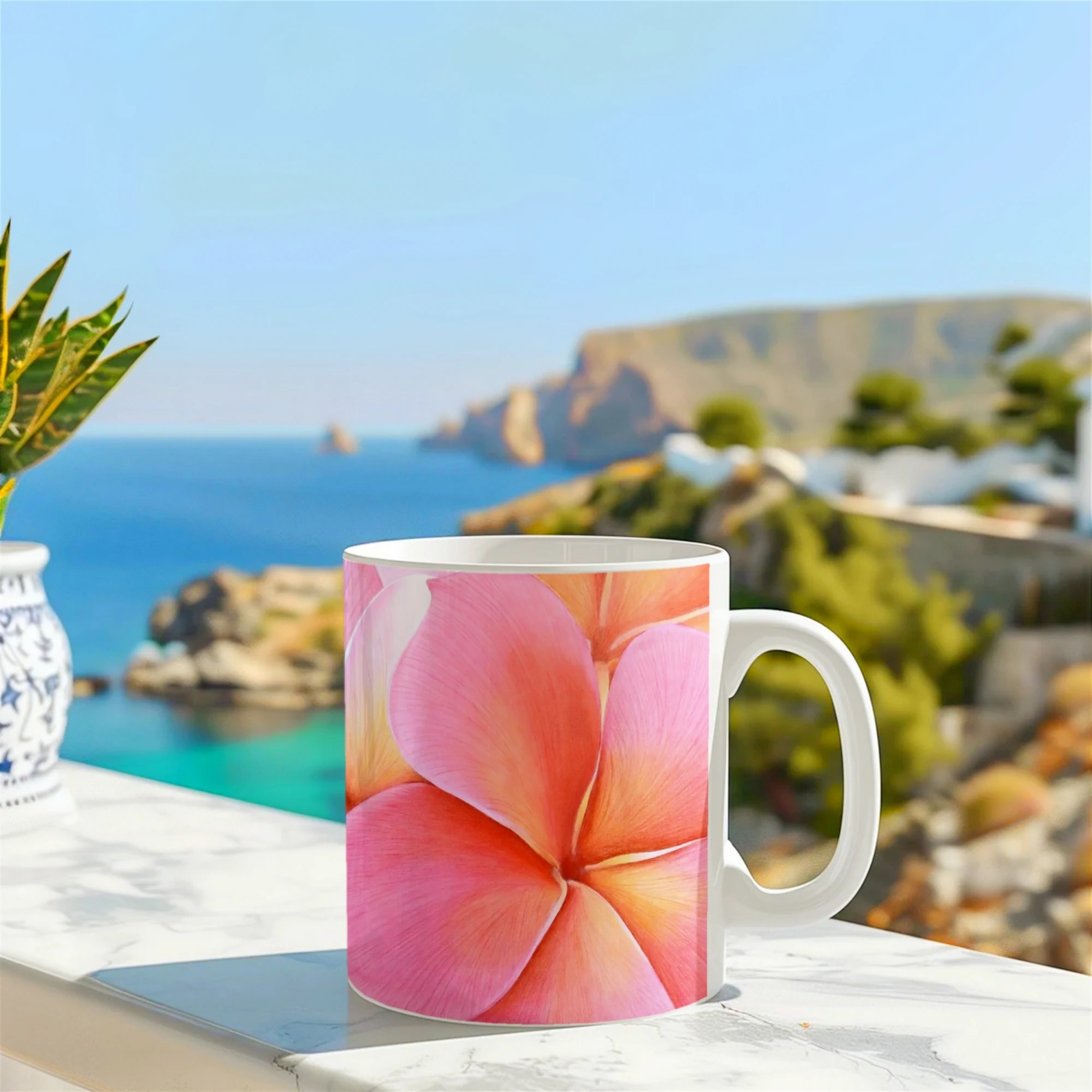 Mug artistique avec des fleurs roses de plumeria posé sur un muret devant la mer, capturant la beauté tropicale.