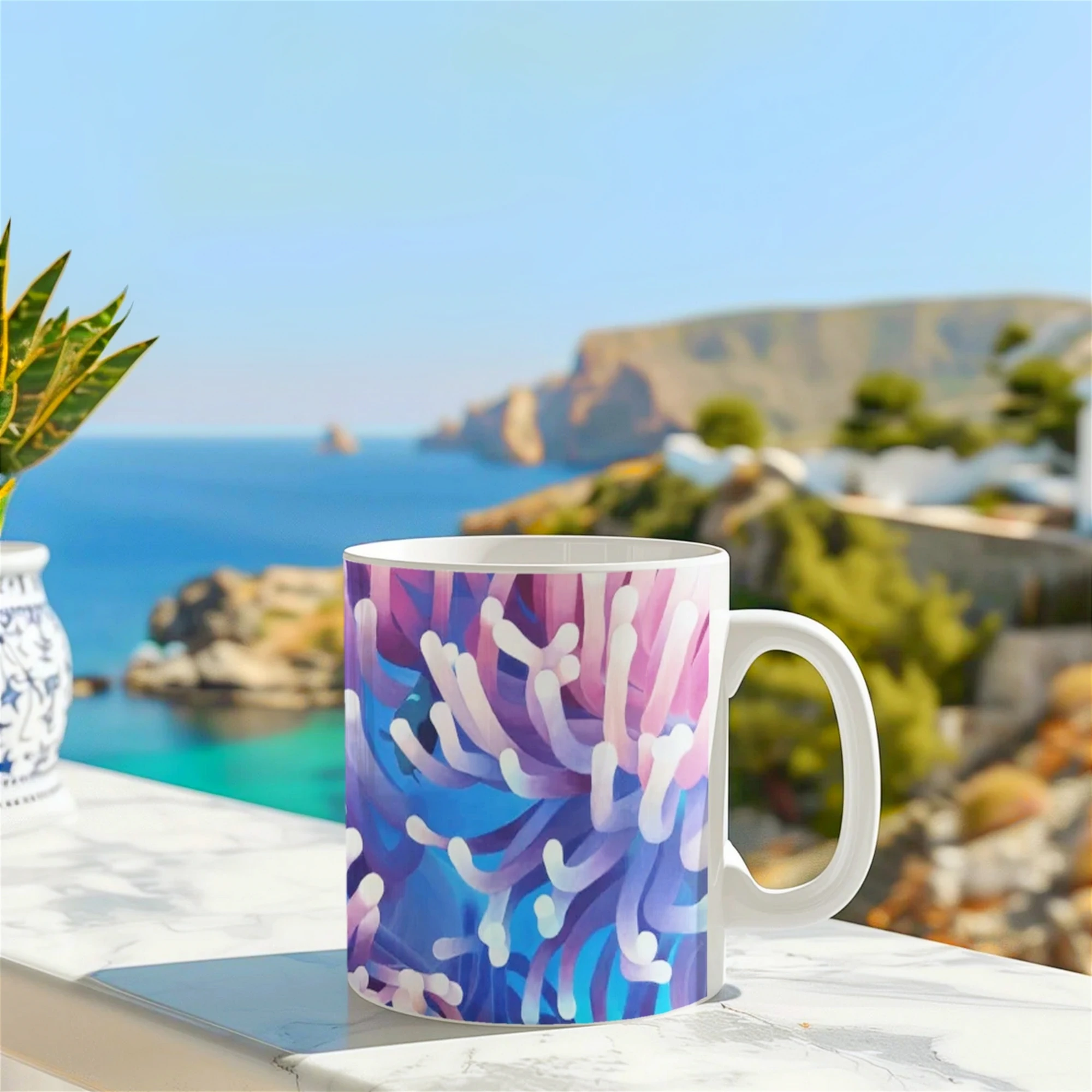Mug avec anémones de mer et poisson, posé sur un muret face à la mer, un design tropical inspiré des fonds marins.