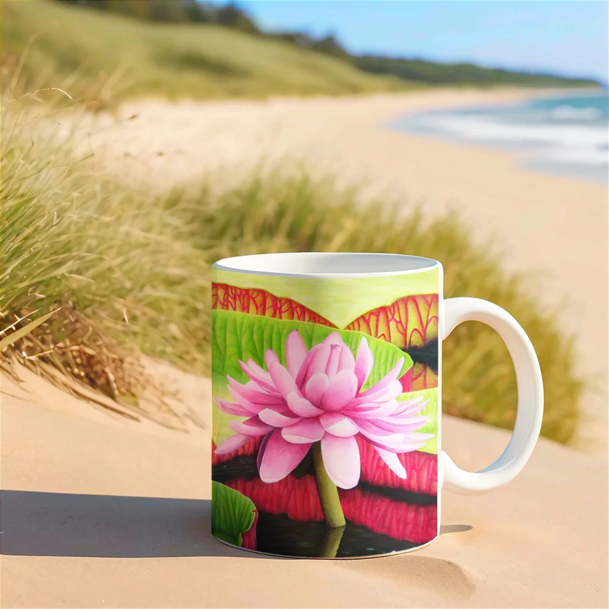 Mug imprimé d'une fleur de nénuphar rose Victoria Amazonica, posé sur le sable, un design naturel et tropical pour vos moments de détente.