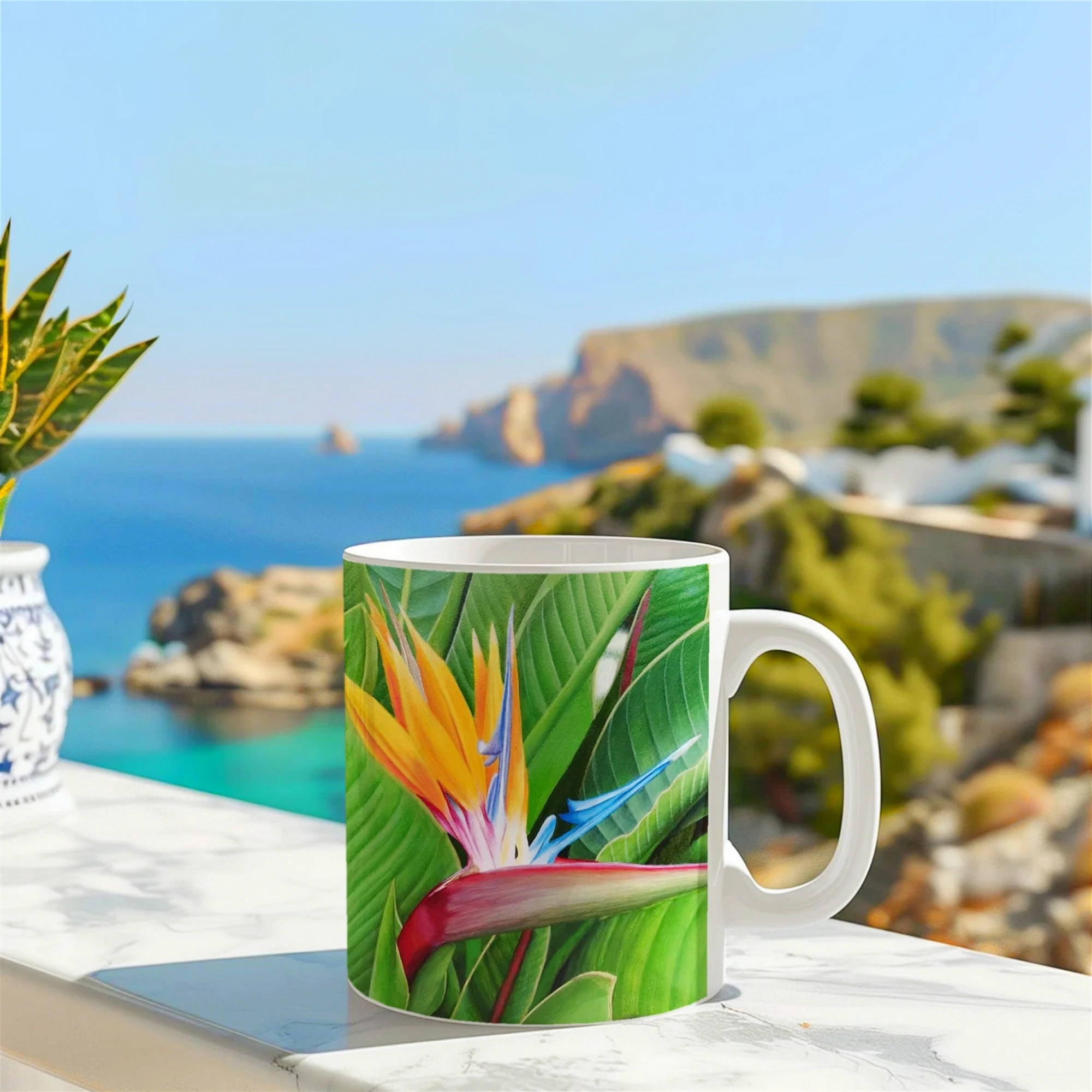 Mug tropical avec une fleur de Strelitzia, posé sur un muret face à la mer, parfait pour une pause café au bord de l'océan.