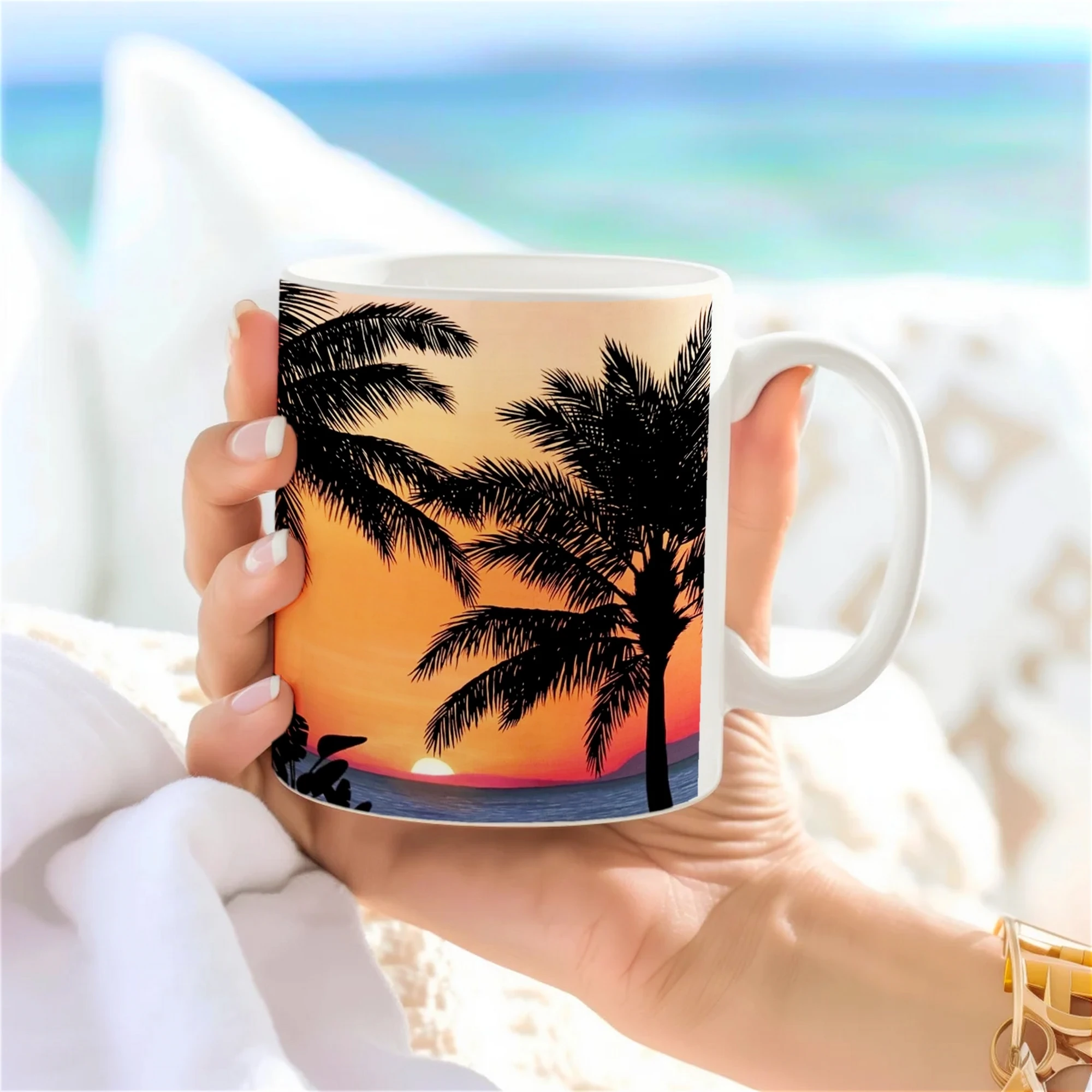 Tasse artistique avec un motif de palmiers sur fond de coucher de soleil orange, vue latérale en main, design exotique et lumineux.