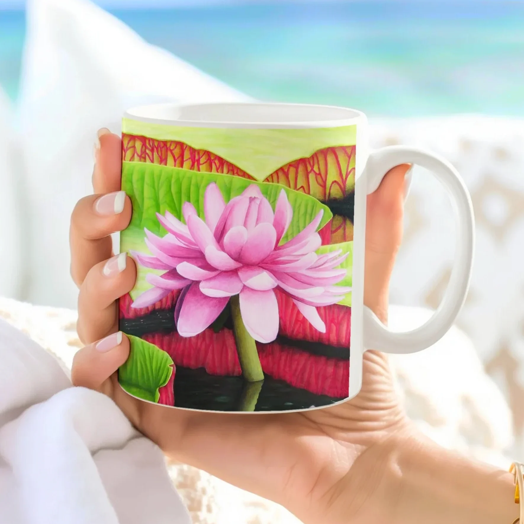 Tasse avec une fleur de nénuphar rose Victoria Amazonica, vue latérale tenue dans une main, un design floral inspiré de la nature.