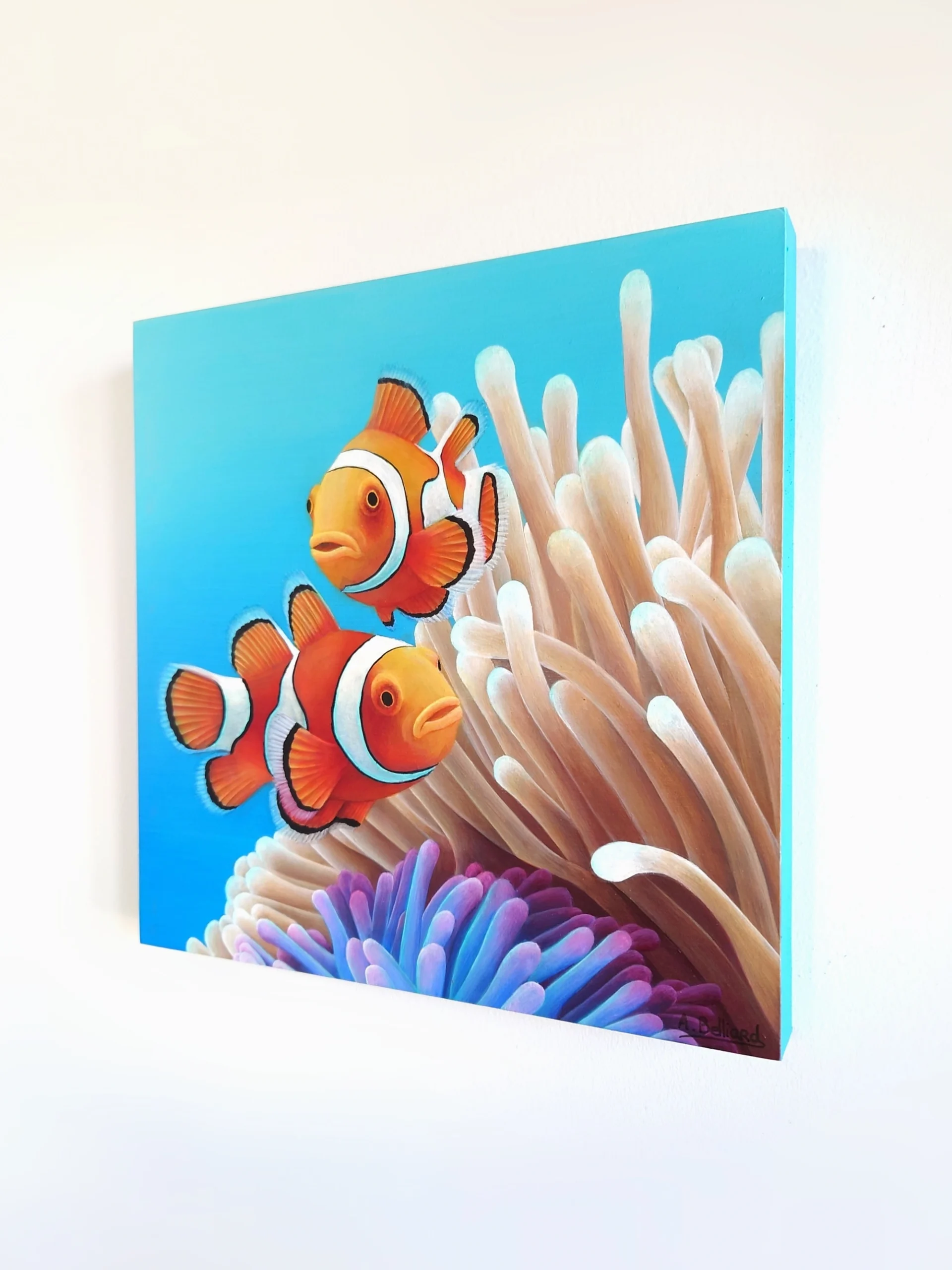 Petit tableau de deux poissons-clowns dans des anémones de mer dans l'océan de taille 20x20 cm accroché au mur.
